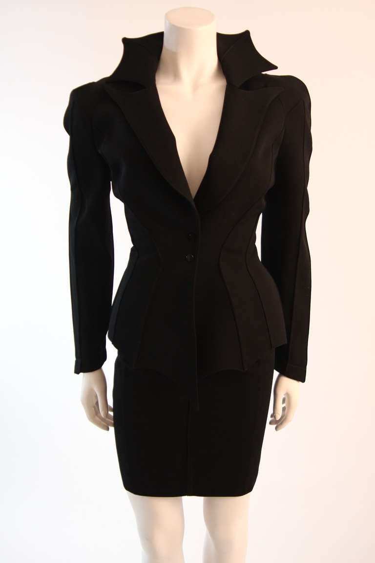 This is a phenomenal black Thierry Mugler skirt suit. In true Thierry Mugler form, this suit features futuristic architectural contouring and stream lines which accentuate the female form in a powerful, sexy, and sophisticated way. The jacket