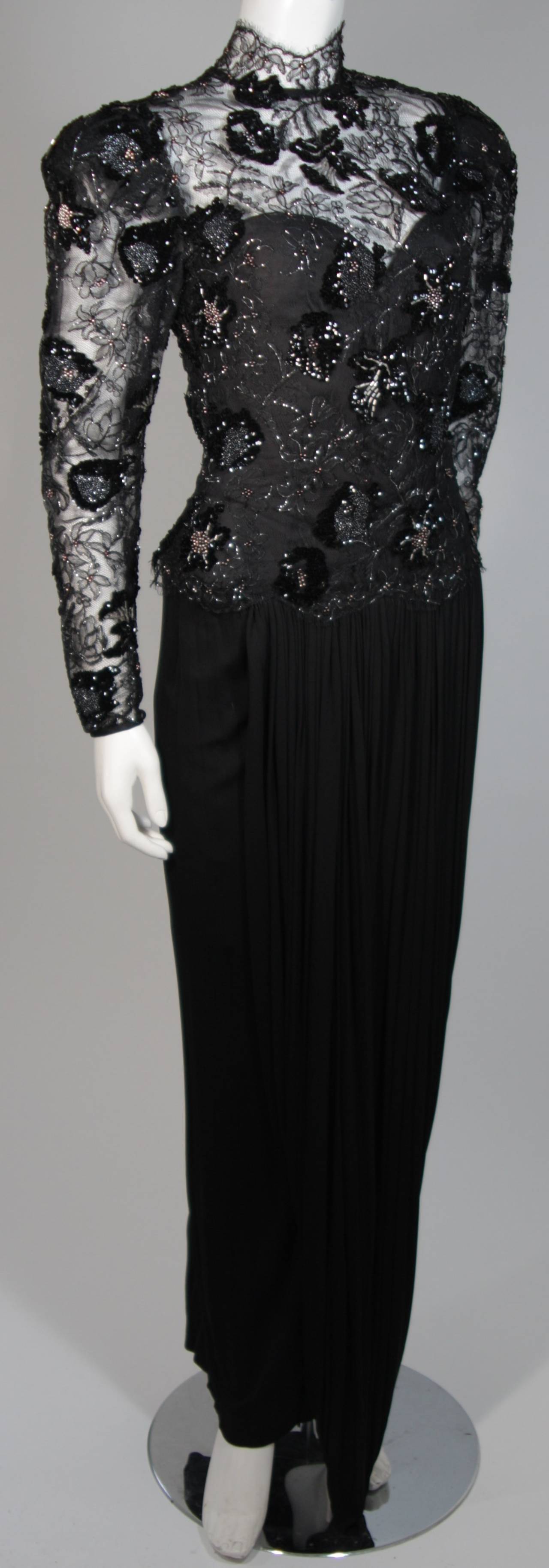 This Vicky Tiel gown is composed of a black sequin black lace with a draped jersey skirt. The bodice features long sleeves and a scallop edge mandarin style collar. The bodice features boning for structure and there is a center back zipper closure