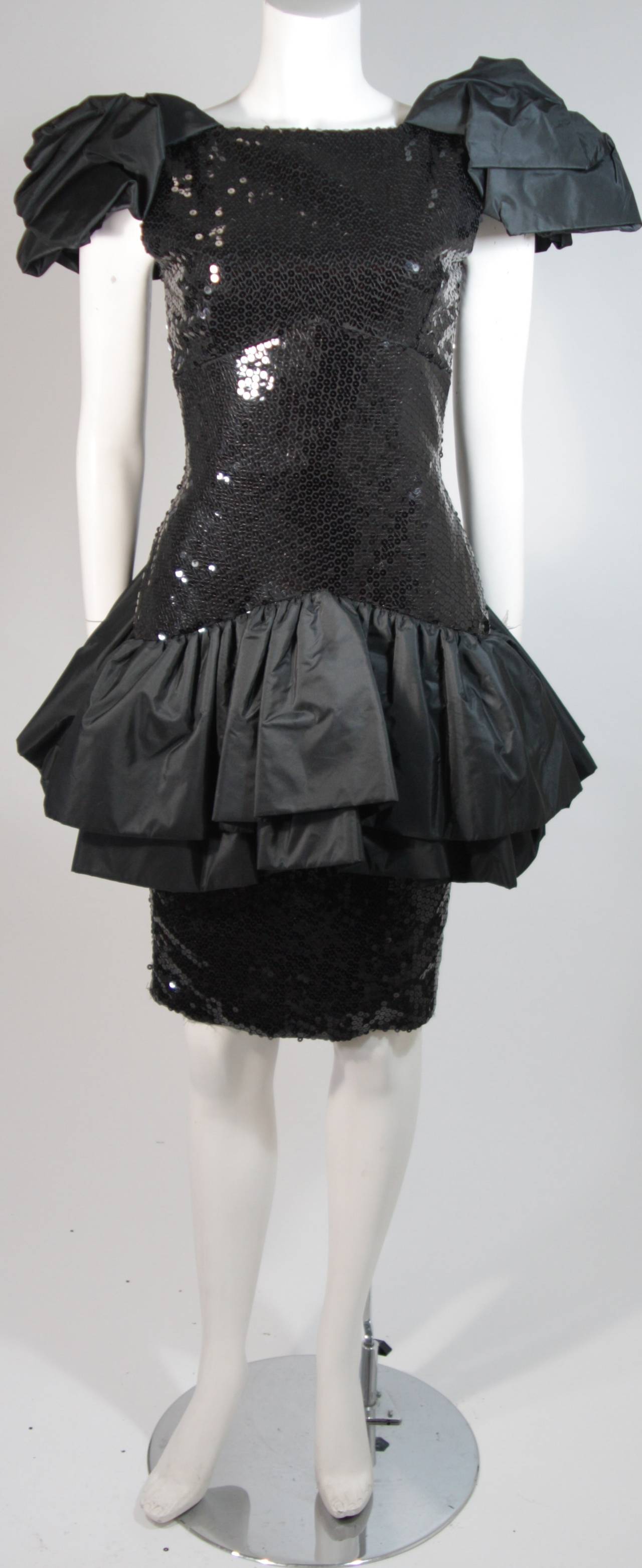 This Vicky Tiel gown is composed of a black silk and a sequined bodice. There are gathers throughout the sleeves and at the hip for a dramatic silhouette. There is a center back zipper closure for ease of access. In excellent condition. Made in