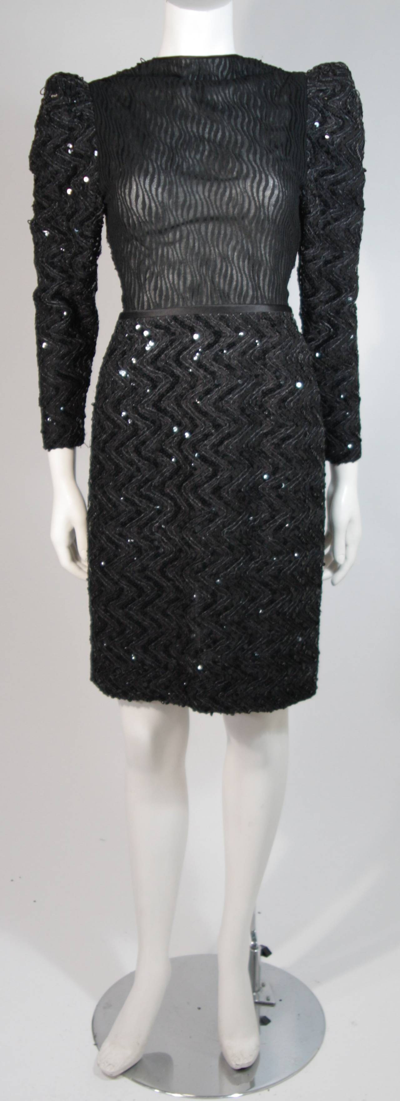 This Vicky Tiel cocktail dress is composed of a black sequin lace and features a sheer bodice. There are gathers at the shoulders for a dramatic effect. There is a center back zipper closure for ease of access. In excellent condition. Made in