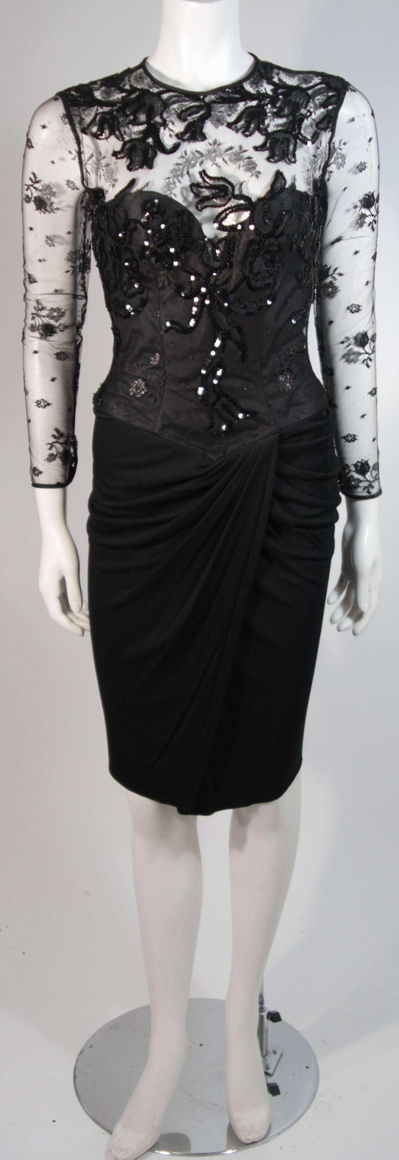 This Vicky Tiel cocktail dress is composed of a black sequin lace and features  a draped jersey skirt. There is a structured interior bustier with boning. There is a center back zipper closure for ease of access. In excellent condition. Made in