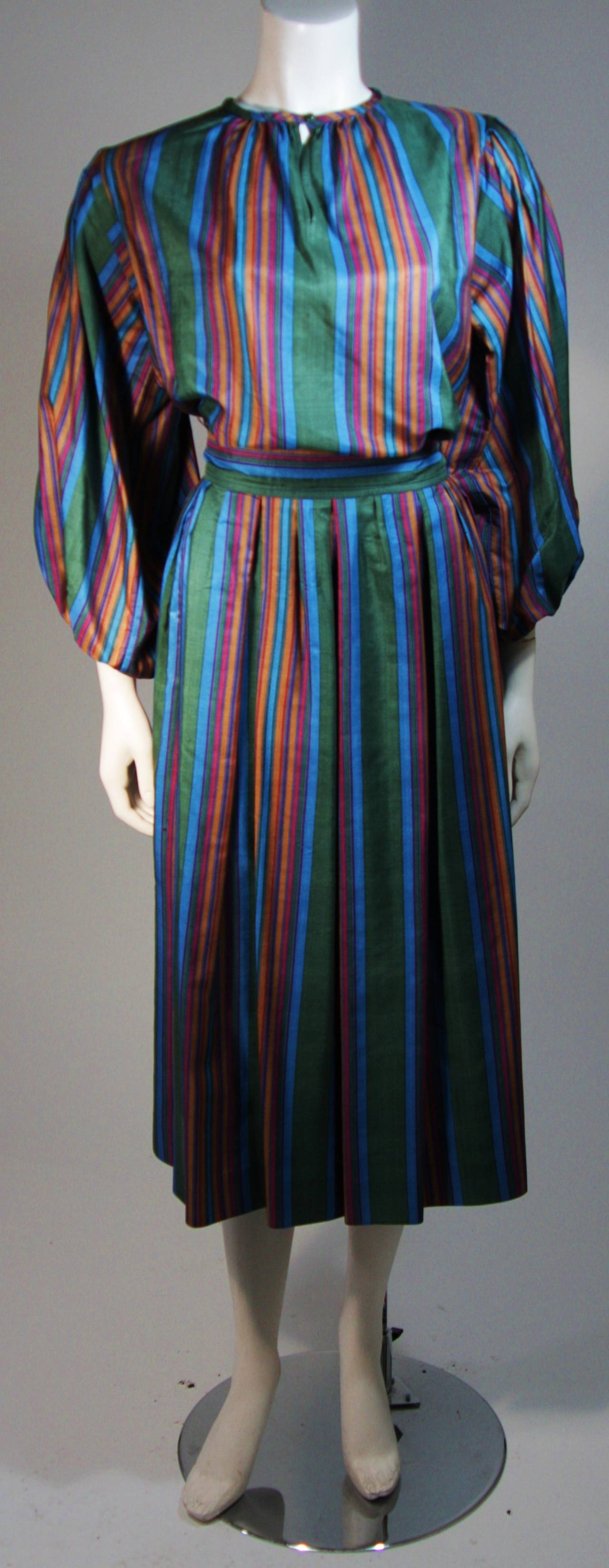 This Yves Saint Laurent set is composed of a silk with a textured finish in a vertical stripe pattern with a color story featuring blue, green, magenta and orange. The slightly oversize top features a keyhole opening with button. the skirt has a