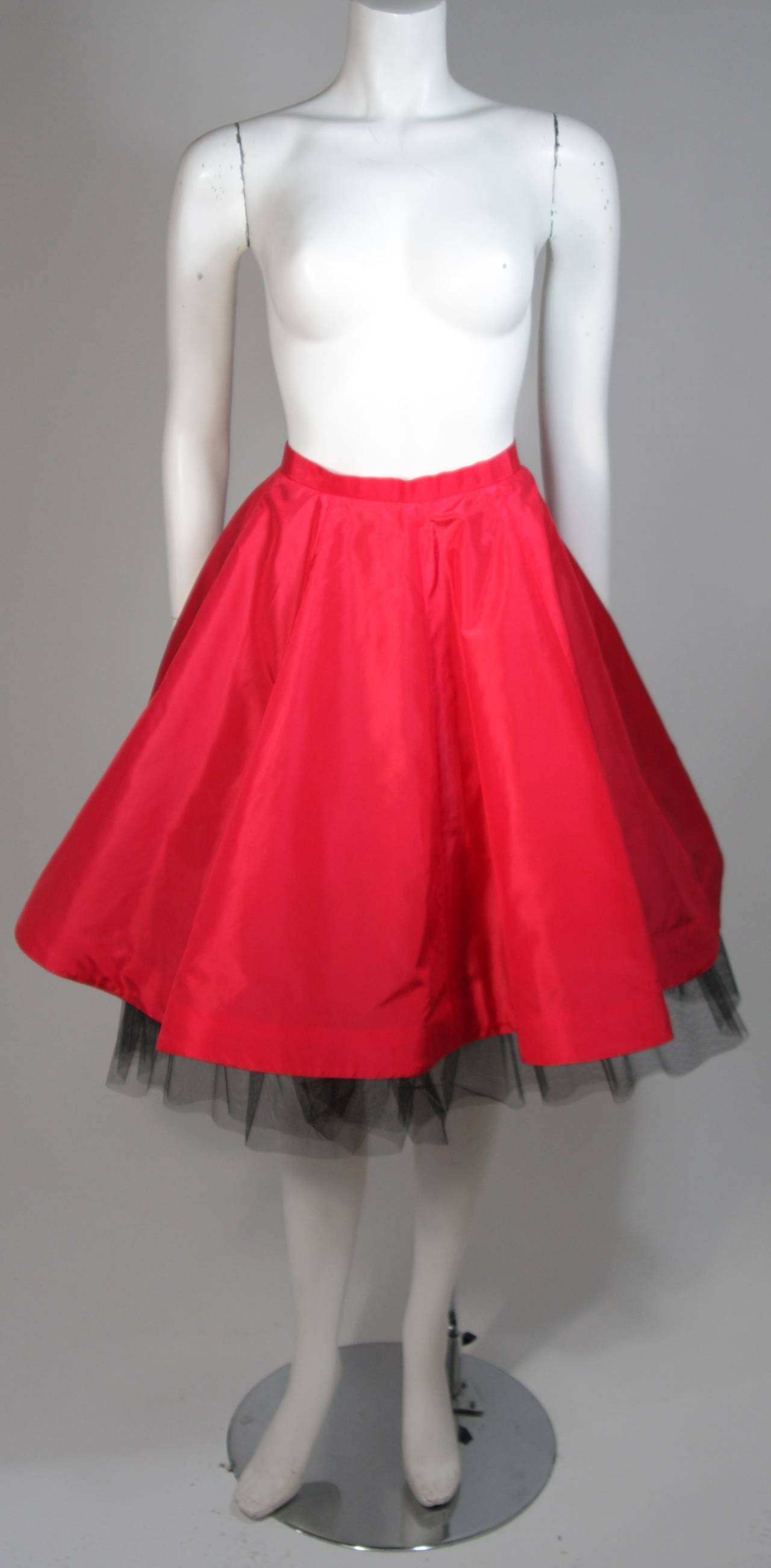 This Oscar De La Renta design is available for viewing at our Beverly Hills Boutique. We offer a large selection of evening gowns and luxury garments. 

 This skirt is composed of a red fabric and features a black crinoline. There are two pieces
