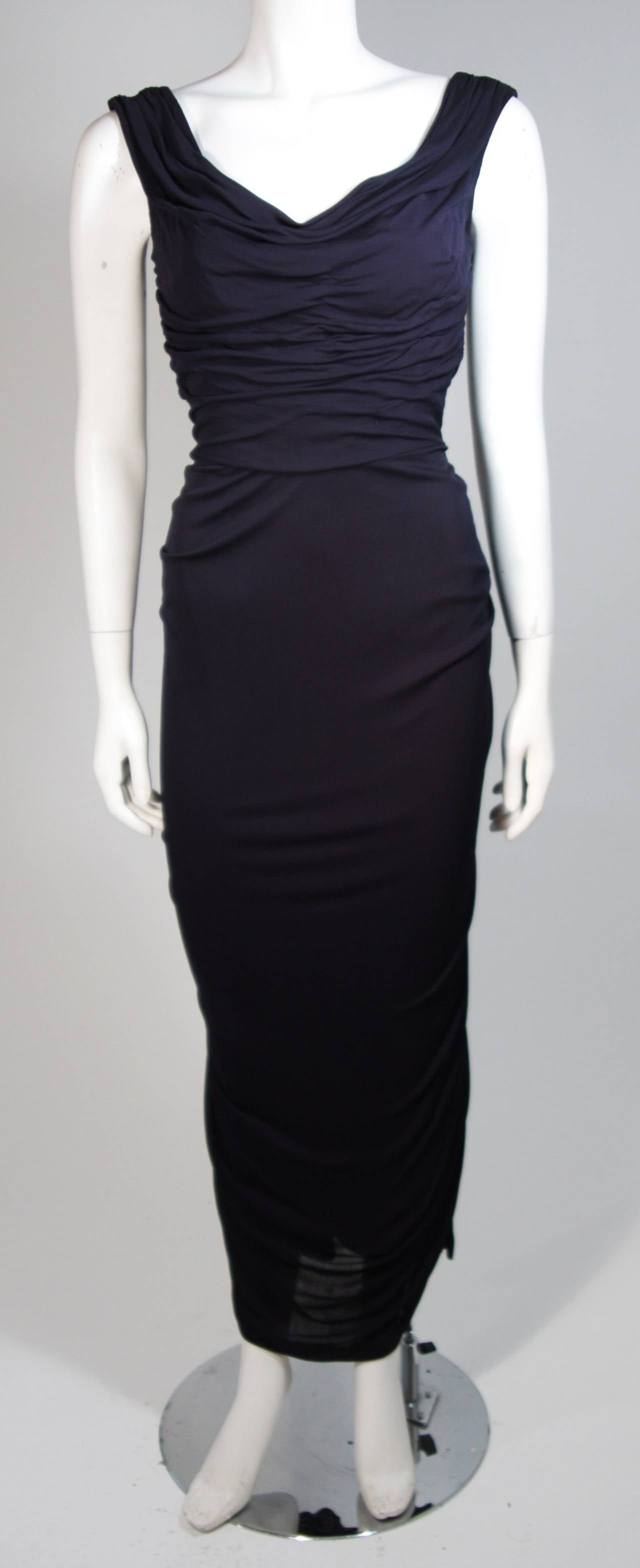 This Ceil Chapman gown is composed of a navy jersey. The dress features draping and straps which can be styled on or off the shoulders. There is a center back drape as well and a zipper closure. In excellent vintage condition. Beautiful for design