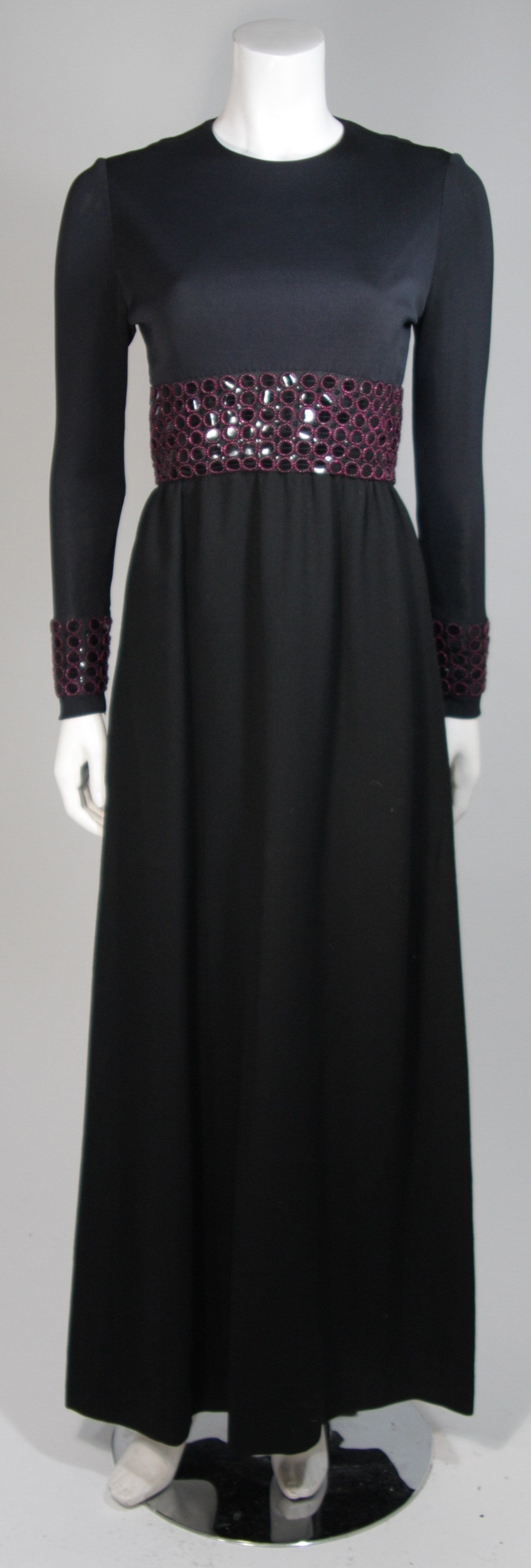 This Chester Weinberg gown is composed of a black tightly woven knit. The dress features magenta/purple bead applique with a sequin backing. There is a center back zipper closure. In excellent vintage condition.

**Please cross-reference