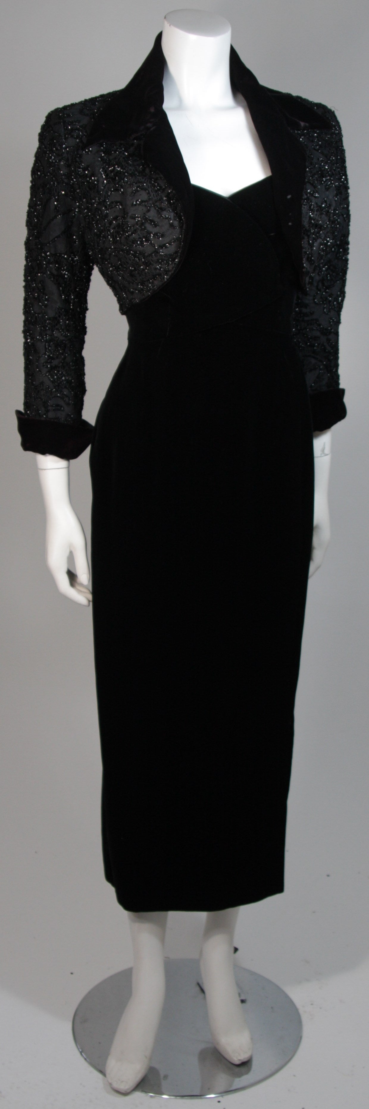 This Howard Greer set is composed of velvet, featuring an embellished bolero with black beading and sequins., The jacket has an open style and is trimmed in velvet. The dress has a zipper closure. In excellent condition.

**Please cross-reference