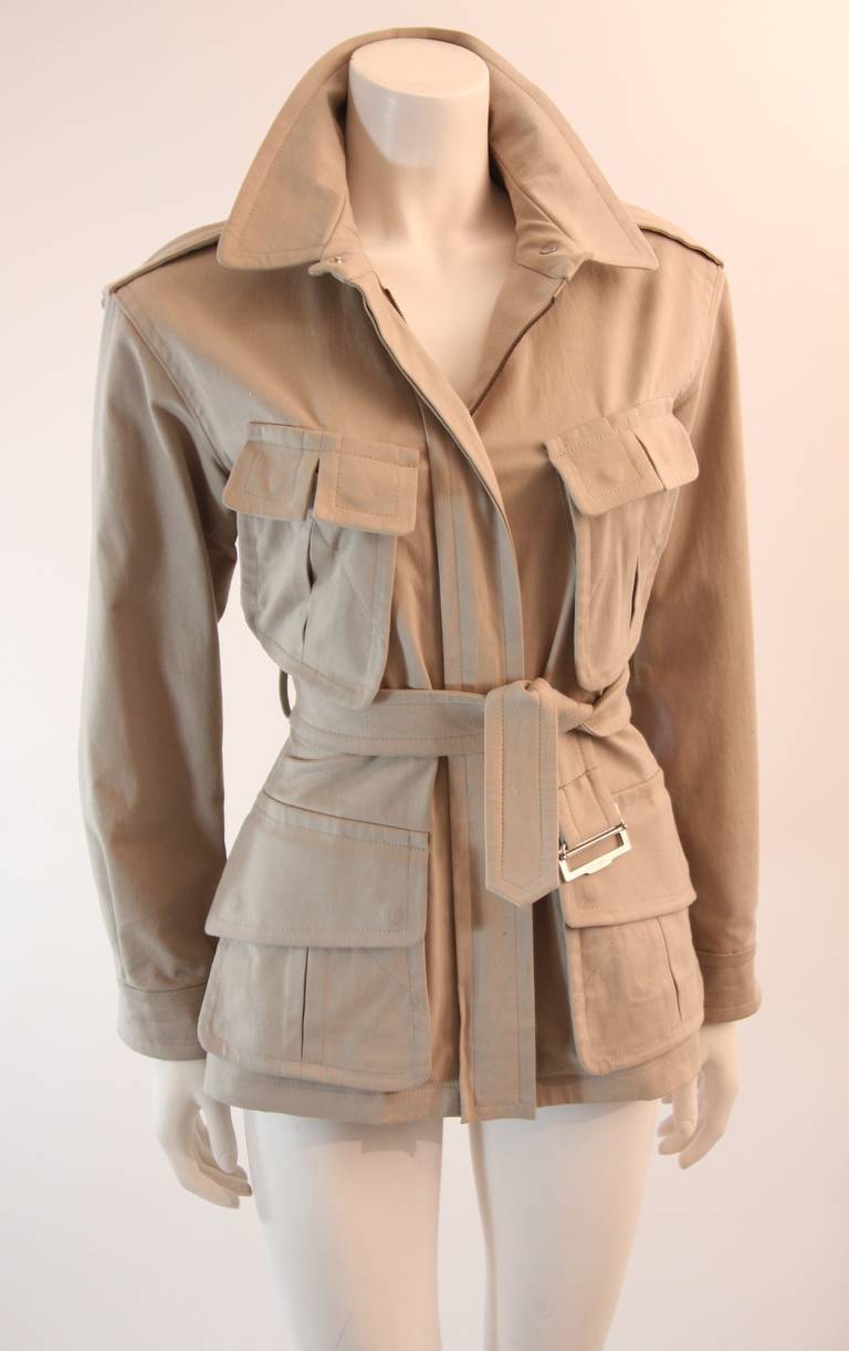 This is an amazing military inspired Yves Saint Laurent Rive Gauche jacket. It is in a wonderful shade of khaki. Featuring four front pockets and a waist belt. This jacket may be worn in a number of ways and styled to your liking. Easily dress this