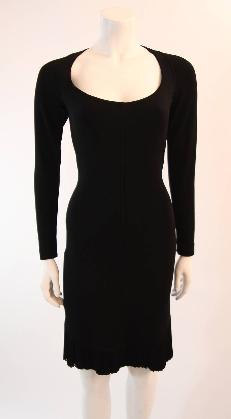 This is a stunning Alaia creation. This form fitting dress is composed of a supple stretchy black rayon and nylon blend which accentuates the body beautifully. The close fitting silhouette of this dress culminates to a pleated flair just above the