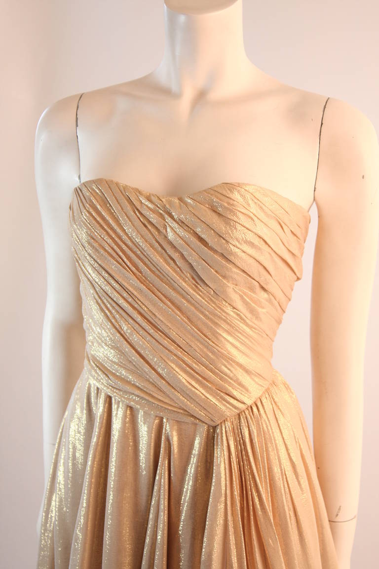 Cette robe Elizabeth Mason Couture est faite de la soie la plus fine lame cette robe est créée à l'atelier d'Elizabeth Mason à Beverly Hills. Fabriqué à la main et conçu avec excellence. 

Ce modèle sans bretelles présente un corsage et une jupe