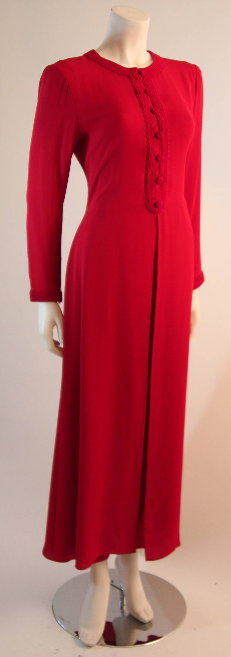 This is a gorgeous Oscar De La Renta pant suit. It is a wonderful hue of original primary red. The color is complimented by the supple and flowing silk fabric. The jacket is trimmed in a wonderful braided accent and center front buttons. The pants