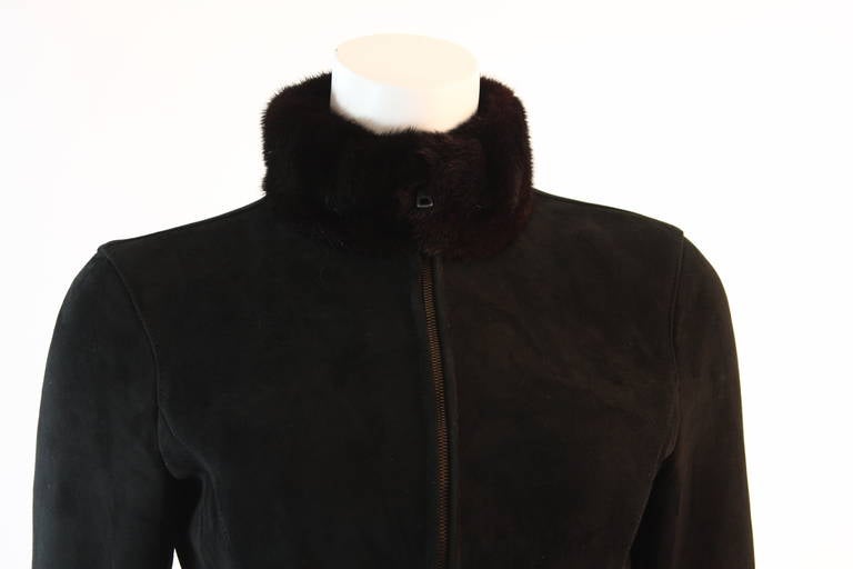 This is a stunning Valentino jacket comprised of black suede, shearling lining, with a mink collar, and patent leather straps at the waist and sleeves. There is a zipper front closure. This jacket is perfect, cozy, and chic. 
Made in