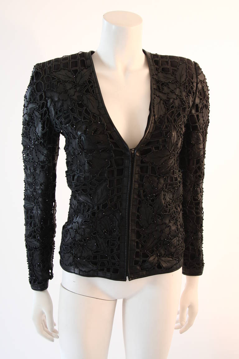 This is a Valentino design. This jacket is impeccably designed and fitted. The Leather is cut precisely into a stunning floral motif and is accented with rhinestones.  Center front zipper closure. Made in Italy. 

Measures (Approximately)
Length: