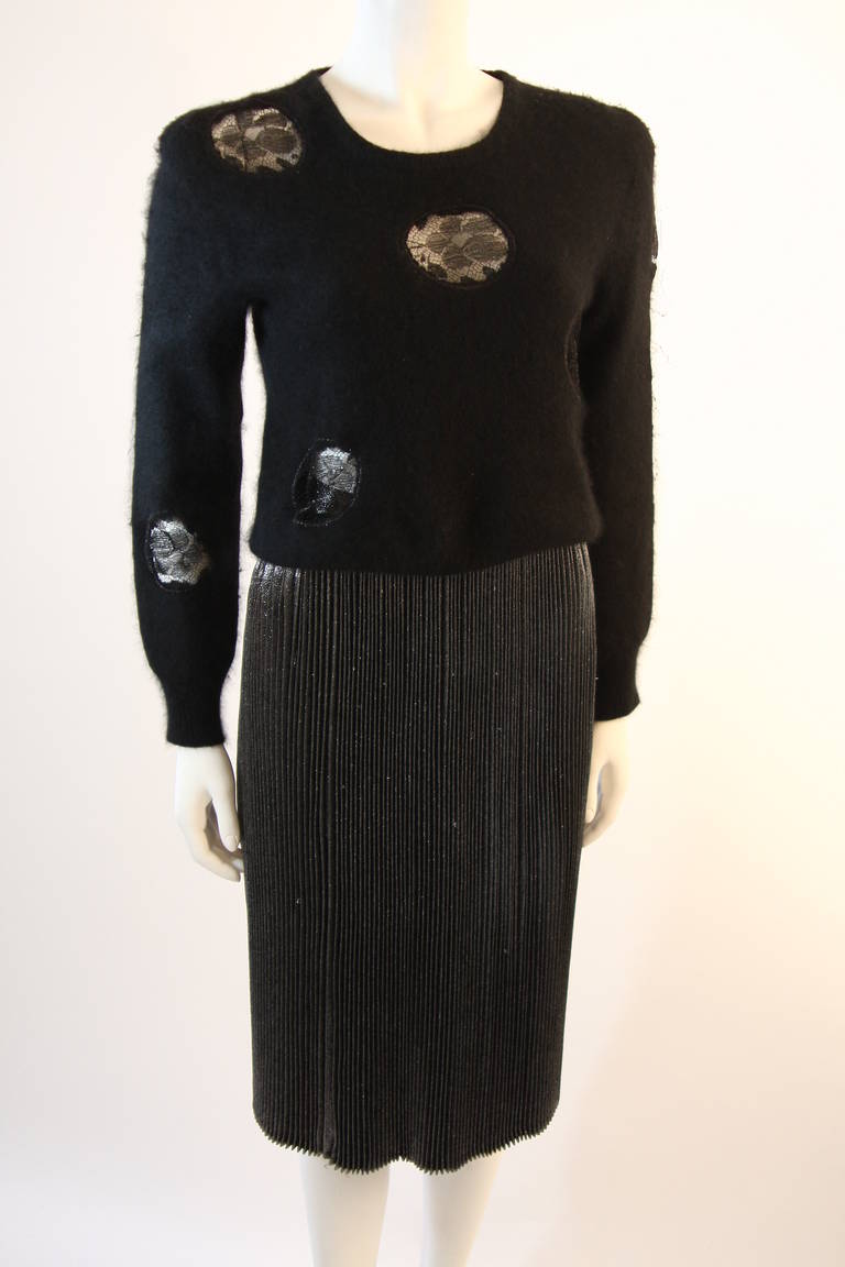 This is a Krizia Maglia set. The set features two pieces, a sublimely soft black angora sweater with lace insets, and a wonderful silver metallic skirt. The supple sweater is a pull-over style crew neck. The lovely skirt is composed of a silver hued