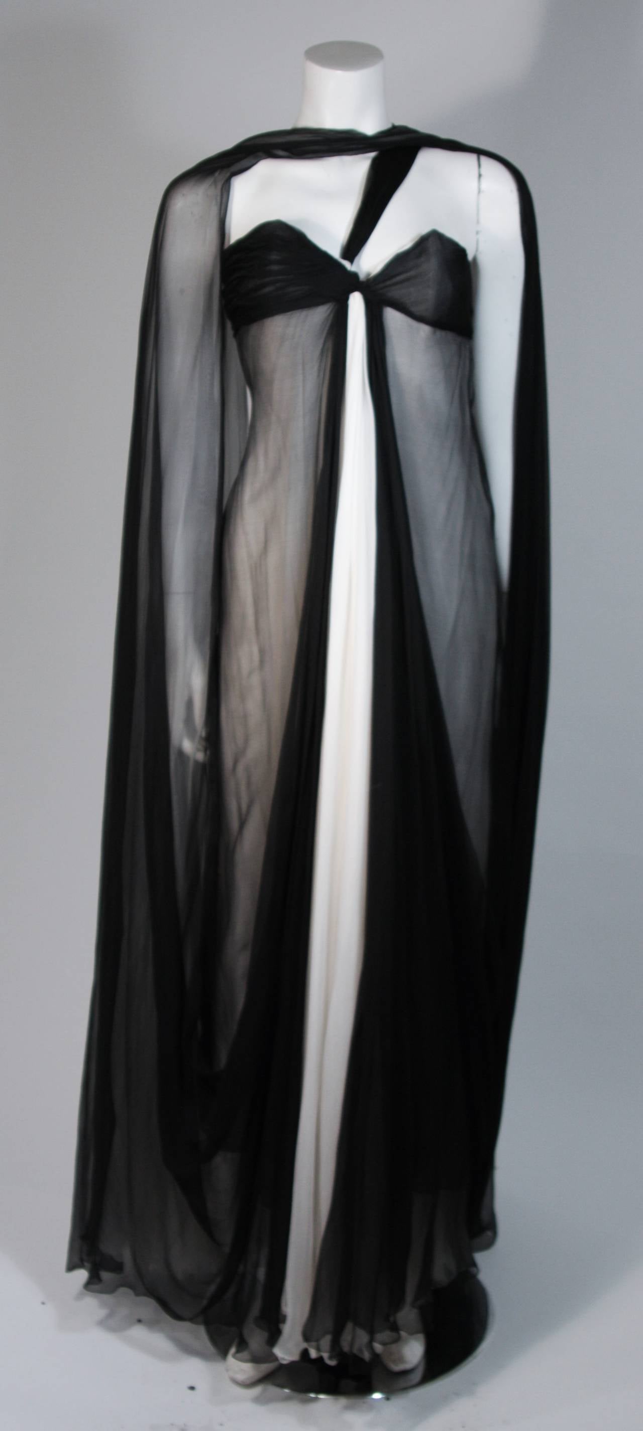 Cette robe Jacqueline De Ribes est composée de mousseline de soie noire et ivoire. La robe présente un drapé qui peut être stylisé et porté à votre guise (voir les variations sur les photographies). Elle est dotée d'une fermeture à glissière au