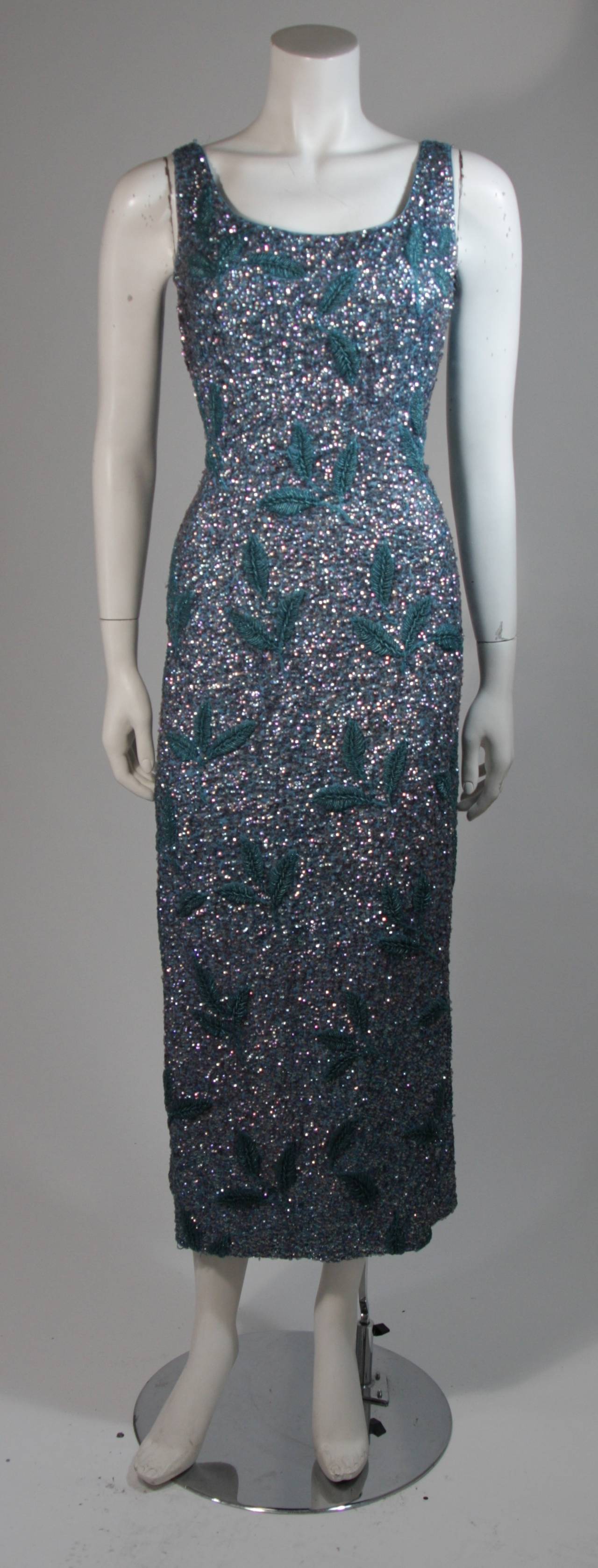 This dress features heavy embellishment with beading and sequins in hues of blue. There is a leaf motif in beading and iridescent sequins. Center back zipper closure. In excellent vintage condition. 

**Please cross-reference measurements for