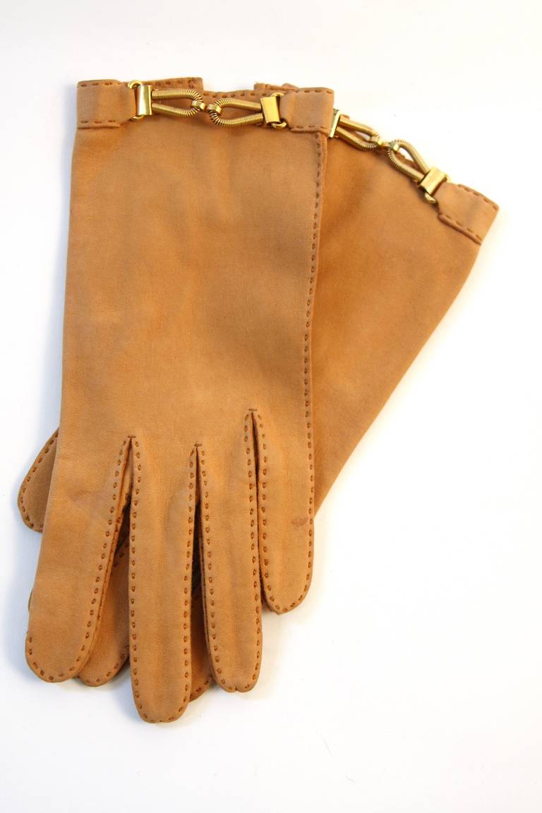 This is a beautiful pair of Roger Fare gloves. They are composed of an ultra supple tan leather and feature fabulous gold hardware with top stitching. Beautiful and easy to use for colder weather. 

Measures (Approximately)
Length: Middle finger