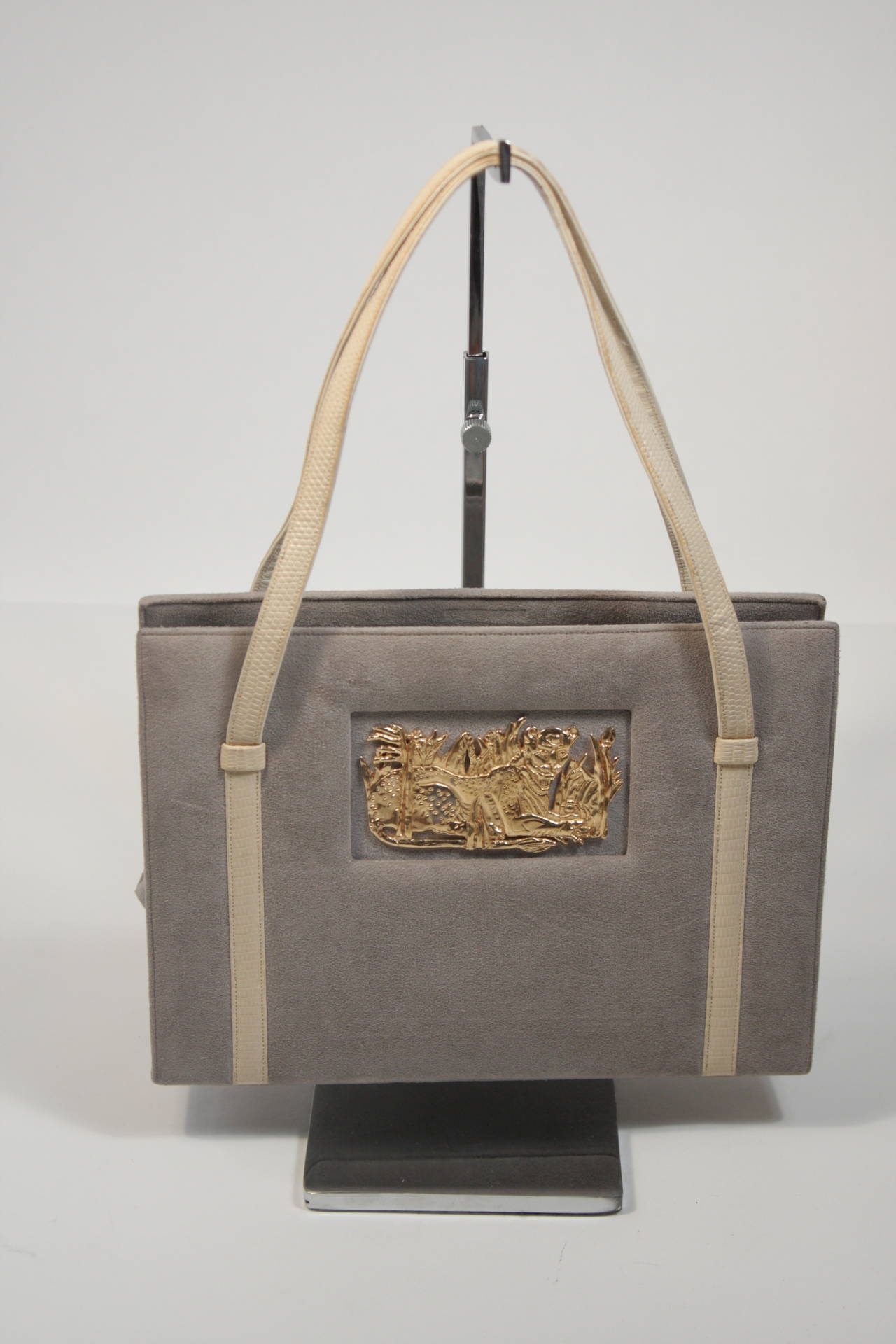 This vintage Martin Van Schaak purse is composed of a light grey suede and features a gold leopard accent. The bags interior is in excellent condition, the outside suede shows has minor discoloration due to age and light use. 

**Please