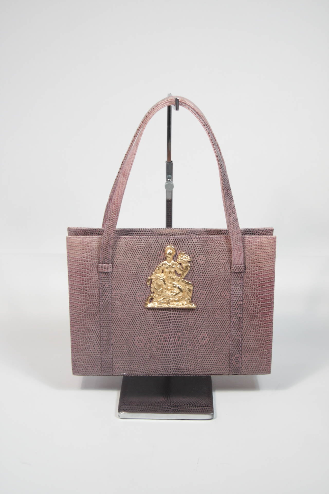 This vintage Martin Van Schaak design is available for viewing at our Beverly Hills Boutique. We offer a large selection of evening gowns and luxury garments.

This purse is composed of a purple snakeskin and features a gold exterior accent of a