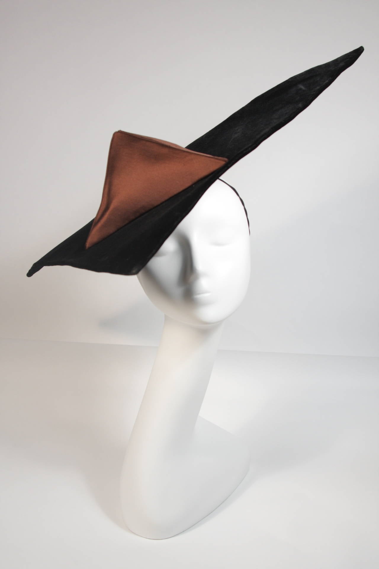 This Yves Saint Laurent Rive Gauche design is available for viewing at our Beverly Hills Boutique. We offer a large selection of evening gowns and luxury garments.

This hat is composed of a brown velvet and silk. The structured triangular hat