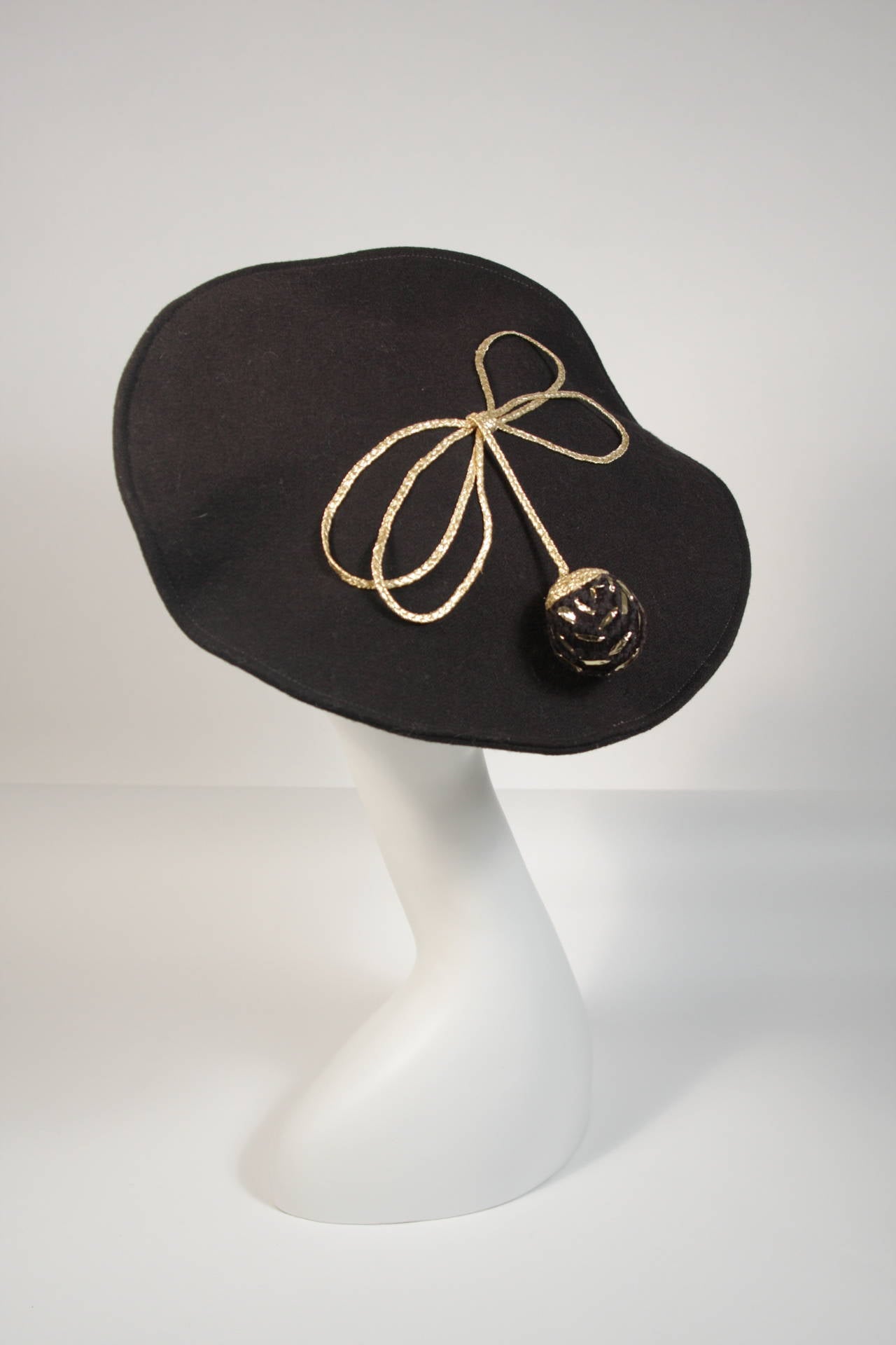 This Yves Saint Laurent Rive Gauche hat is composed of a black wool. The hat features a knit ball with metallic accents set in a bow. In excellent vintage condition. Made in France.

This YSL hat is from an extensive collection I acquired from the