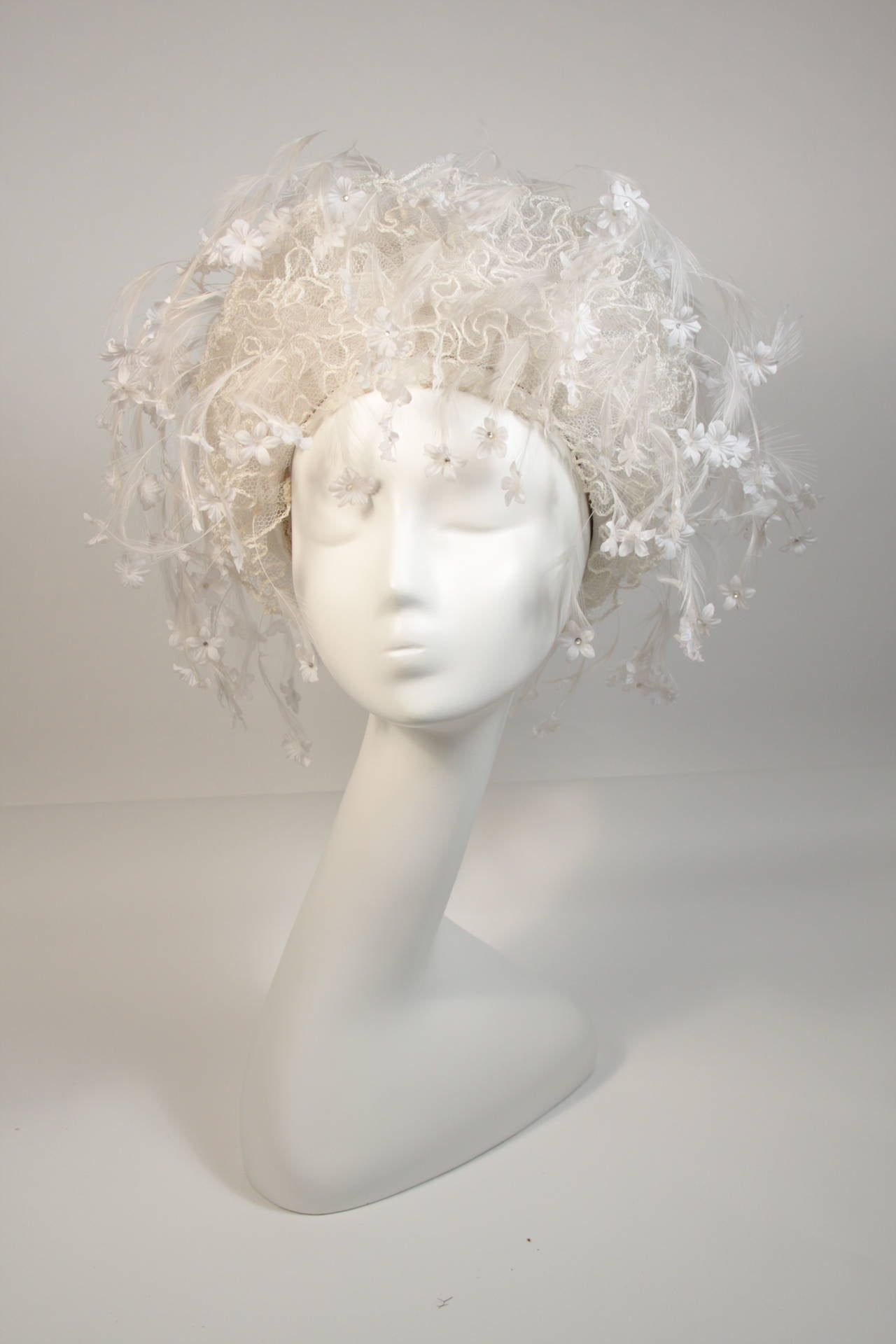 This Jack McConnell hat is composed of a white mesh and features a floral design with feathers and rhinestones. There is a malleable metal base. In excellent vintage condition. Made in NYC.

**Please cross-reference measurements for personal