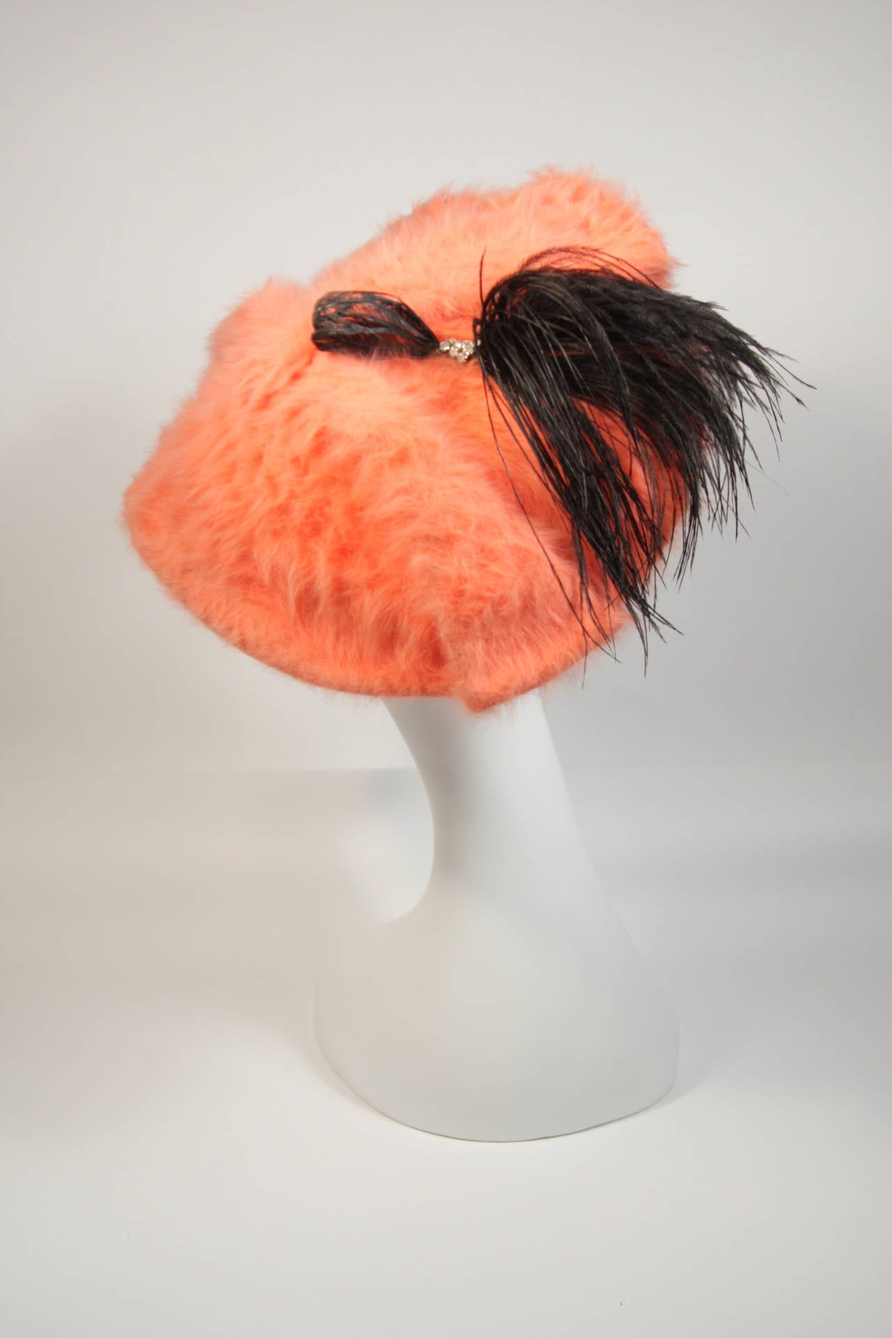 This Esther hat is composed of a bright orange fur and features a black feather with rhinestone detail. In excellent vintage condition, there is some slight discoloration from dust (will likely come out with cleaning). A burst of vibrancy and