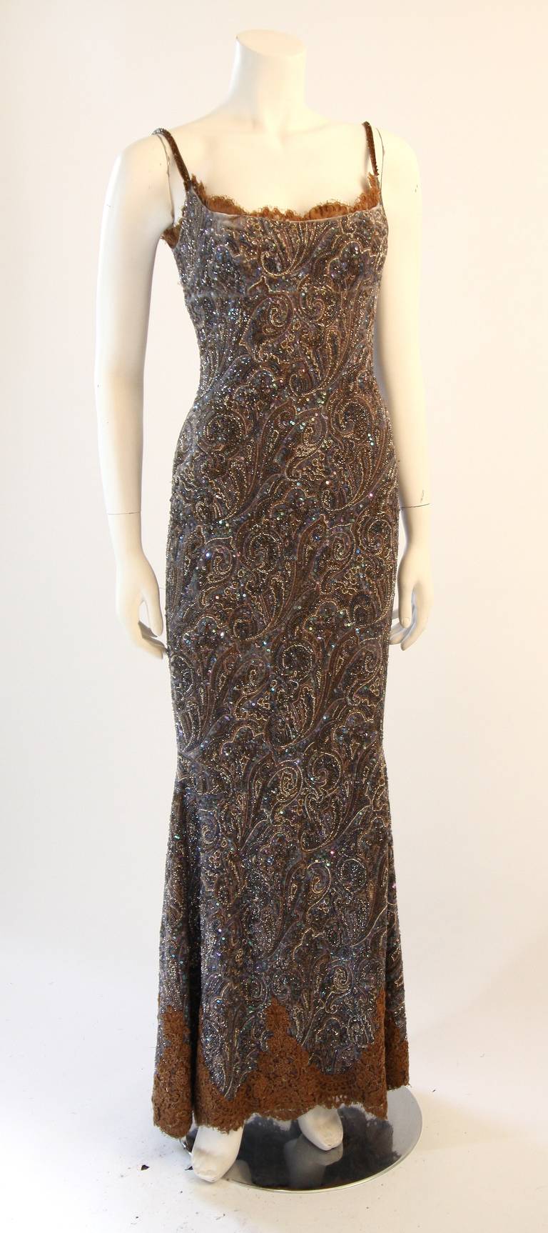 Este es un vestido exquisito de Randi Rahm. El vestido es un precioso diseño con tirantes y adornos de encaje marrón. Se compone de un terciopelo con estampado paisley adornado con cuentas y pedrería. Incorpora una cremallera lateral para facilitar