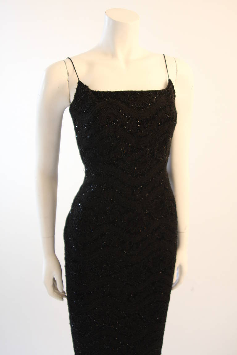 This is an exquisitely beaded Carmen Marco Valvo design. The spaghetti strapped gown in embellished with wonderful black beads and features a classic 3/4 length. Center back zipper for ease of access. 

Measures (Approximately)
Size 6
Length: