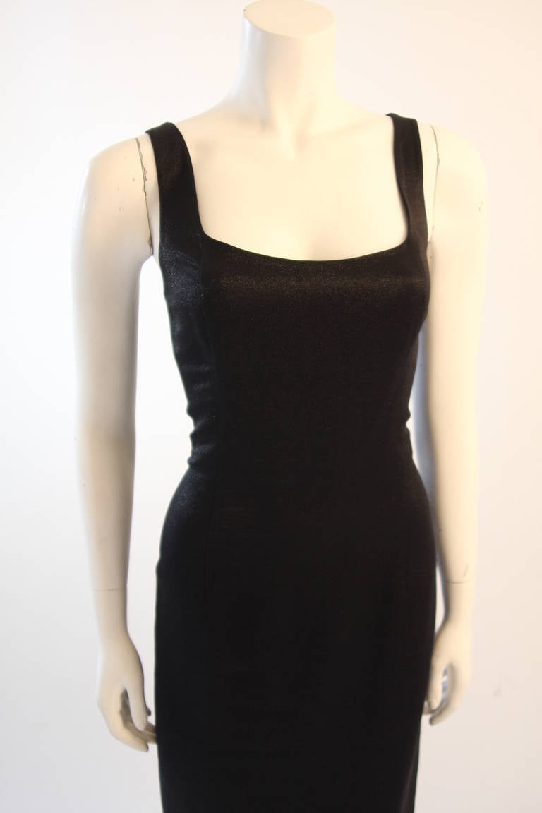 This is a Versace gown. The dress is missing the original larger label, removed for comfortable wearing, but the smaller labels remain intact. Features a center back zipper and classic streamline silhouette. Composed of a black metallic Silk,