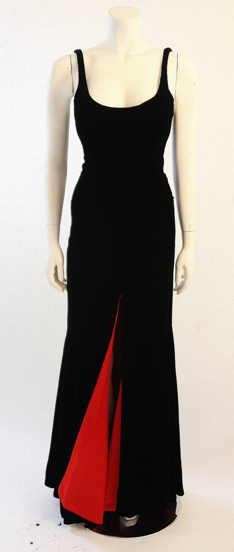 This is a stunning Nolan Miller design. This beautiful gown is composed of a lush black velvet and is lined with an eye catching Cardinal red. This is a dress of dreams and red carpets. Center back zipper.

 The lining has one stain, it is not in