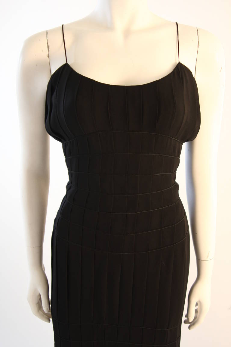 C'est une robe brillante de Thierry Mugler. La robe présente un merveilleux motif plissé et est composée d'une belle soie noire. Il y a une fermeture à glissière au centre du dos ainsi qu'une accentuation par un pompon. Une robe magnifique et sans