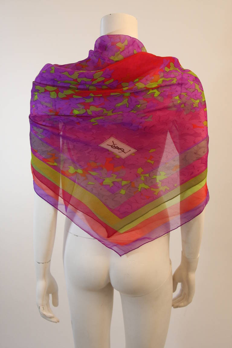 This is a Yves Saint Laurent scarf. This scarf is composed of a beautiful light weight silk and features a brilliant floral pattern in purple, green, and red. Made in France. 

Measures (Approximately)
53