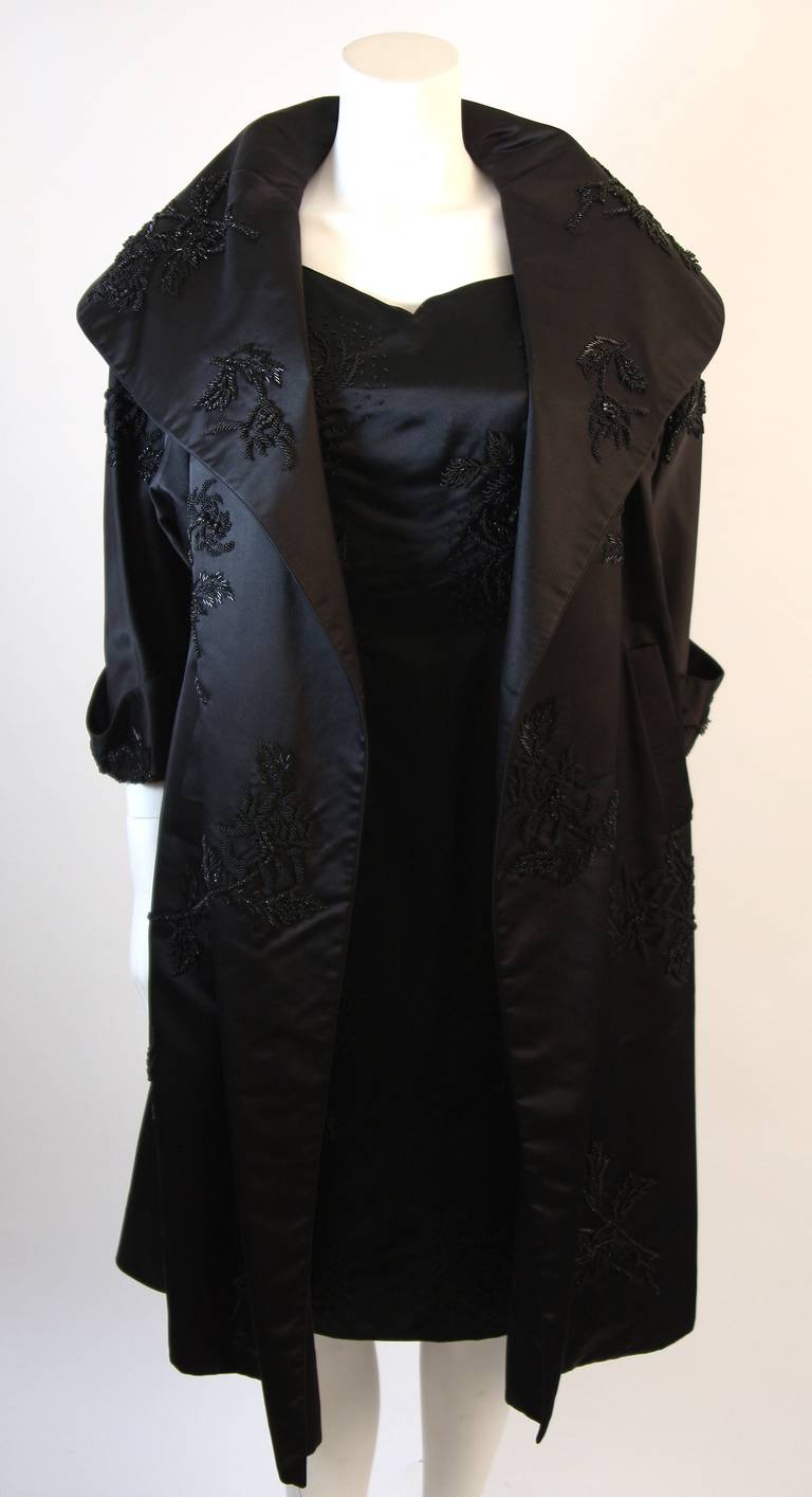 This is a custom 1950's opera coat and cocktail dress ensemble. This set is composed of a beautiful black beaded silk. The exquisite opera coat is striking with or without the stunning cocktail dress. This is a rare and beautifully maintained set.