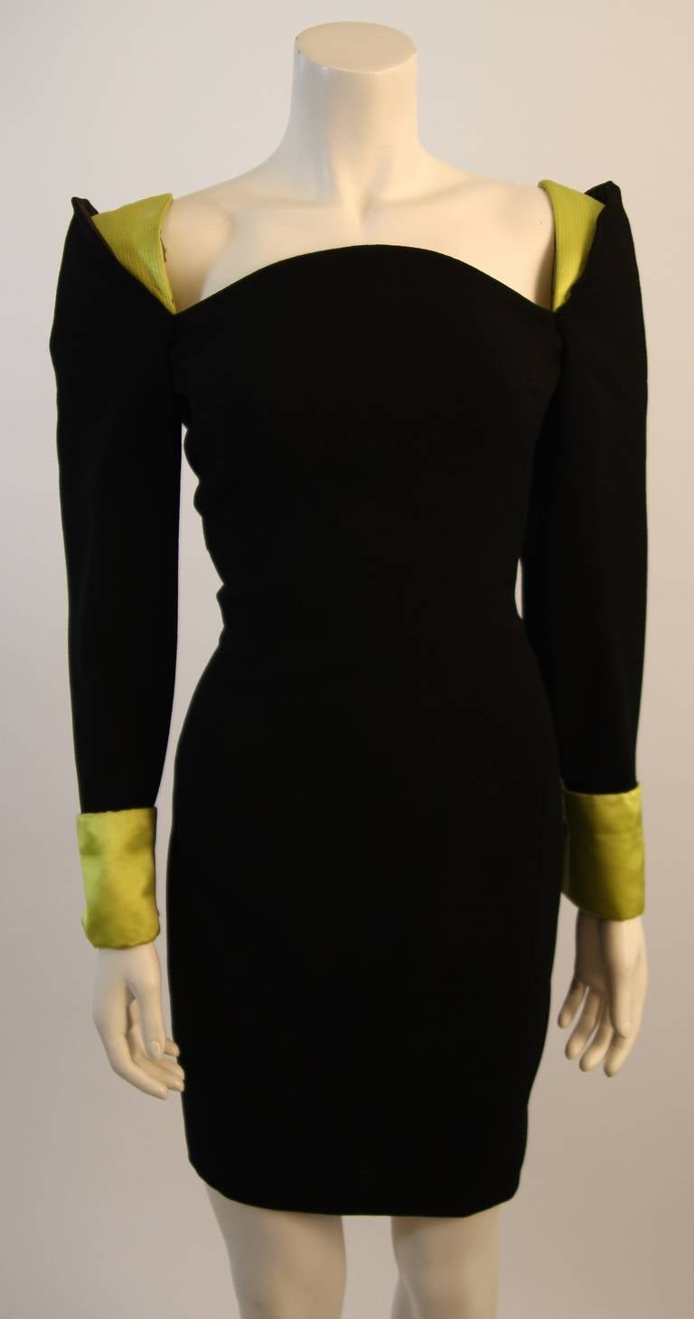 This Gianni Versace design is available for viewing at our Beverly Hills Boutique. The dress is composed of a black fabric which accented with lime hued silk at the shoulders and cuffs. There is a back zipper closure. Made in Italy. 

Please feel