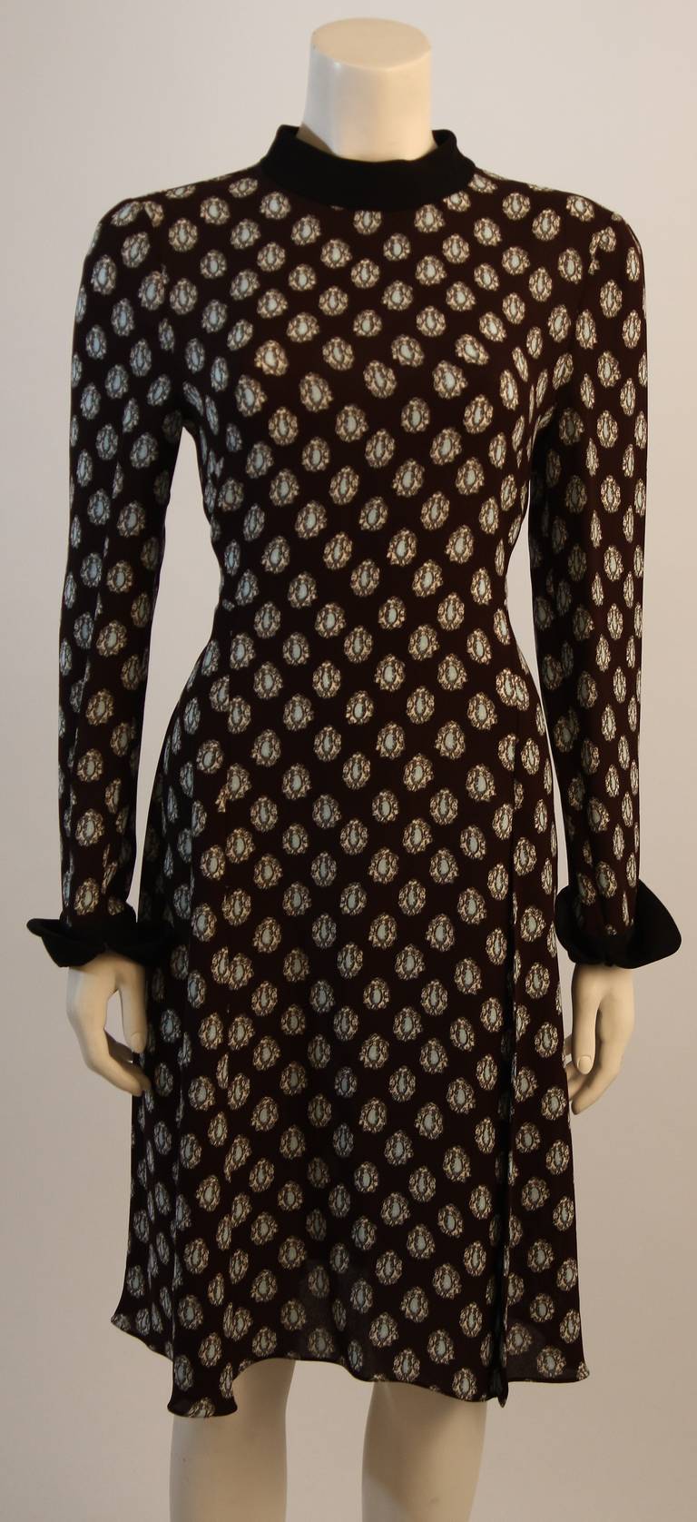 This is a chic Marni day dress. The dress features a wonderful brown and blue print with a mock neck. The skirt is designed with a bit of a flare which is beautifully balanced by a fabulous cuff. There is a center back zipper. Original tags