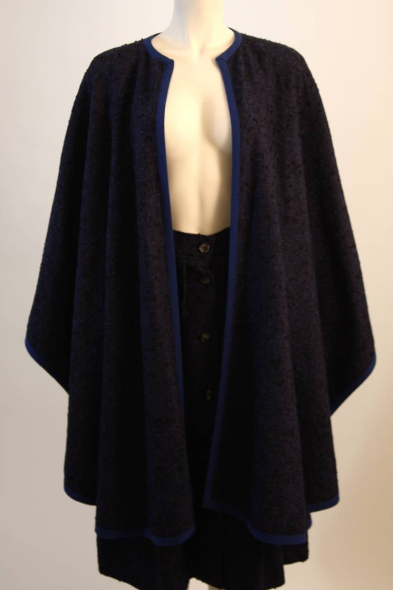 This is a spectacular Yves St. Laurent ensemble. The set is composed of a superb wool in a blue hue with black accent. The skirt features center front button closures. 

Measures (Approximately)
Cape
Size 38
Length: 40