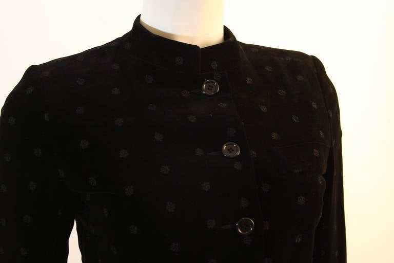 This Yves Saint Laurent jacket is composed out of a black patterned velvet and features a nehru collar design. There are front pockets and center front pockets. Circa 1960's-1970's. The lining has faded, but the jacket is in excellent condition