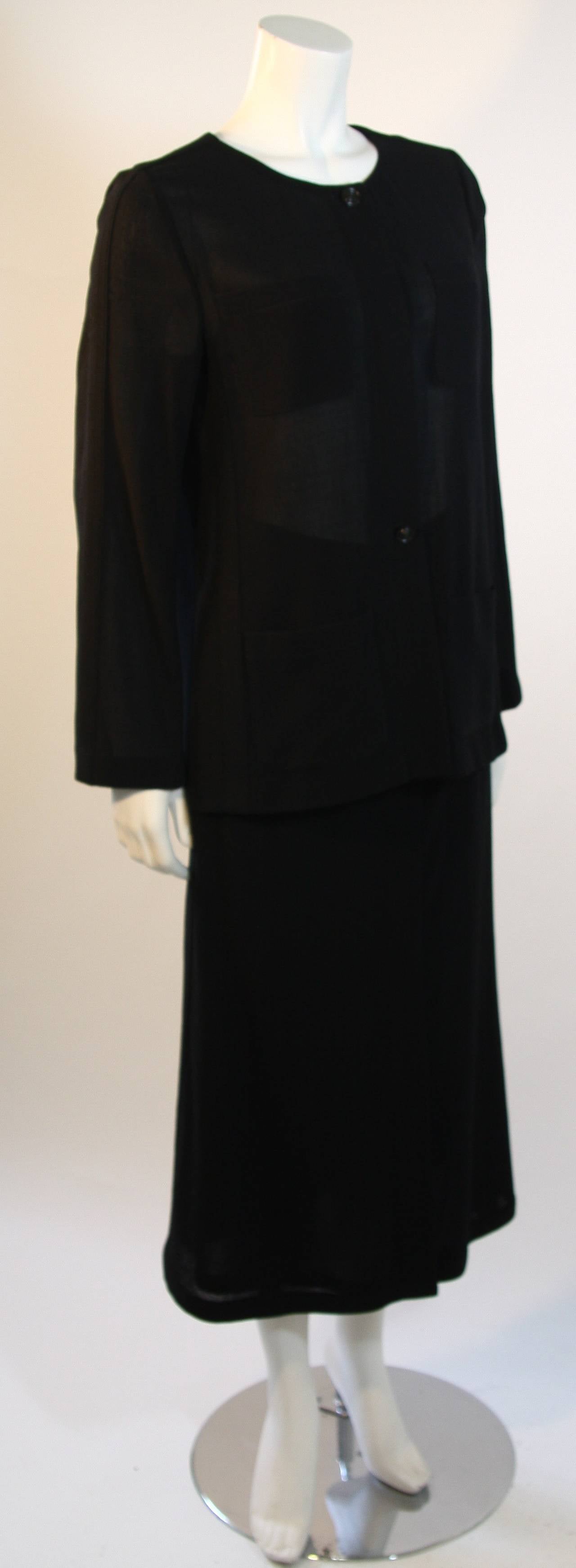 Fabulous collarless jacket or blouse made of wool crepe with visible black top button and center buttons with a hidden button placket down middle front with four pockets, long welt seam detail sleeves, and side seam detail. The original store price