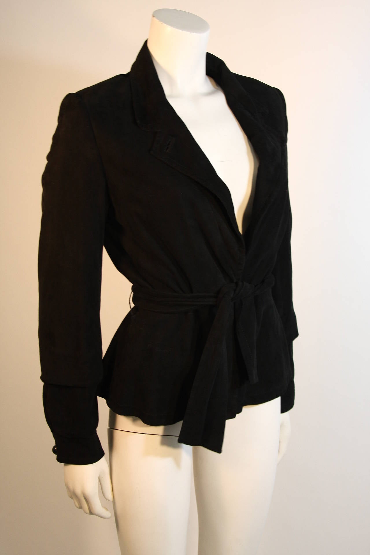 This Yves Saint Laurent jacket is available for viewing at our Beverly Hills Boutique. The jacket is composed of a butter soft suede and features a wrap style. There is a center front waist hook and eye fastening as well as a button at the neck.