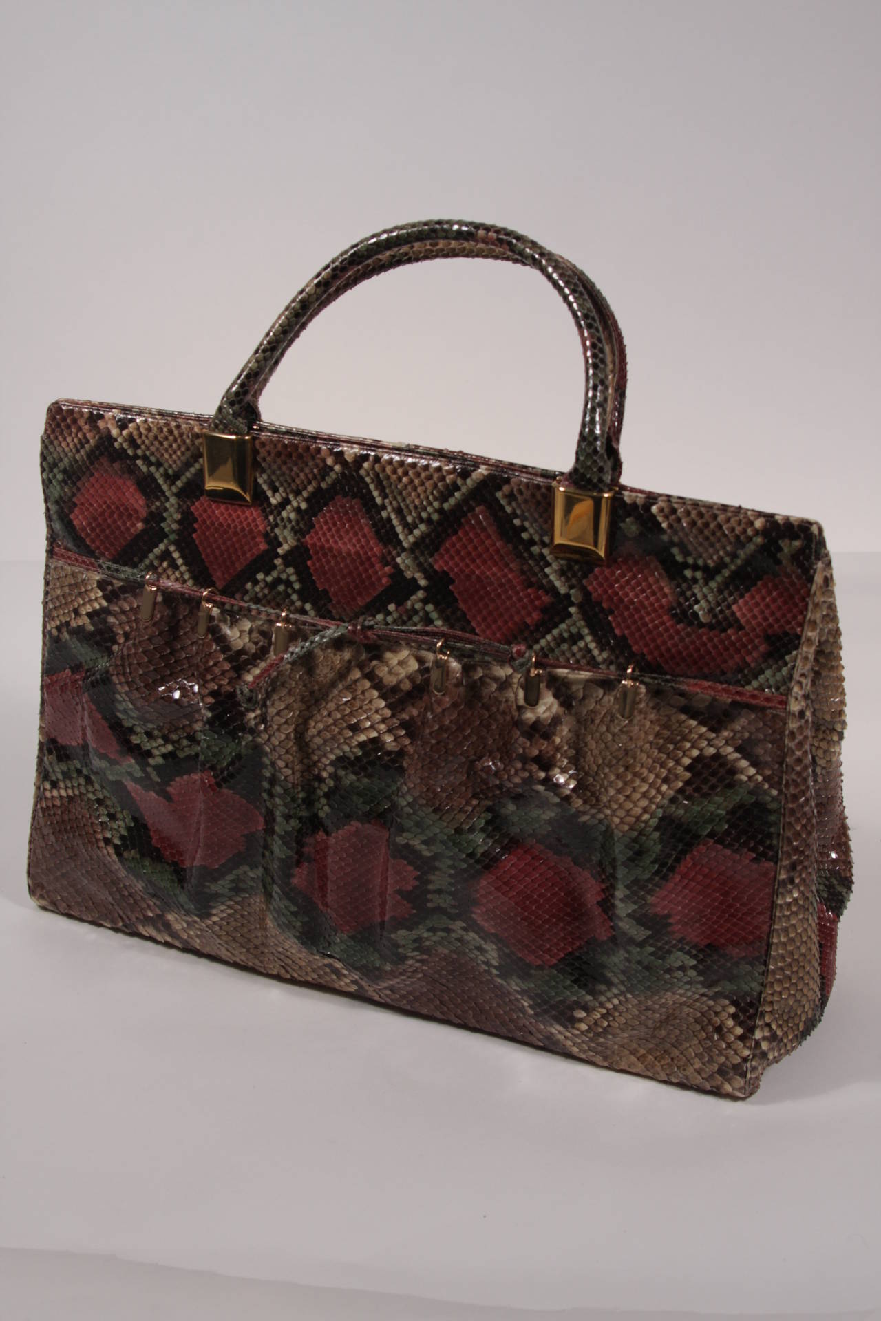 This is a gorgeous Judith Leiber tote. The handbag is composed of a striking multi-colored snakeskin and features a front pocket with gather details. There are two interior zipper compartments and snap closures. Comes with large coin purse attached