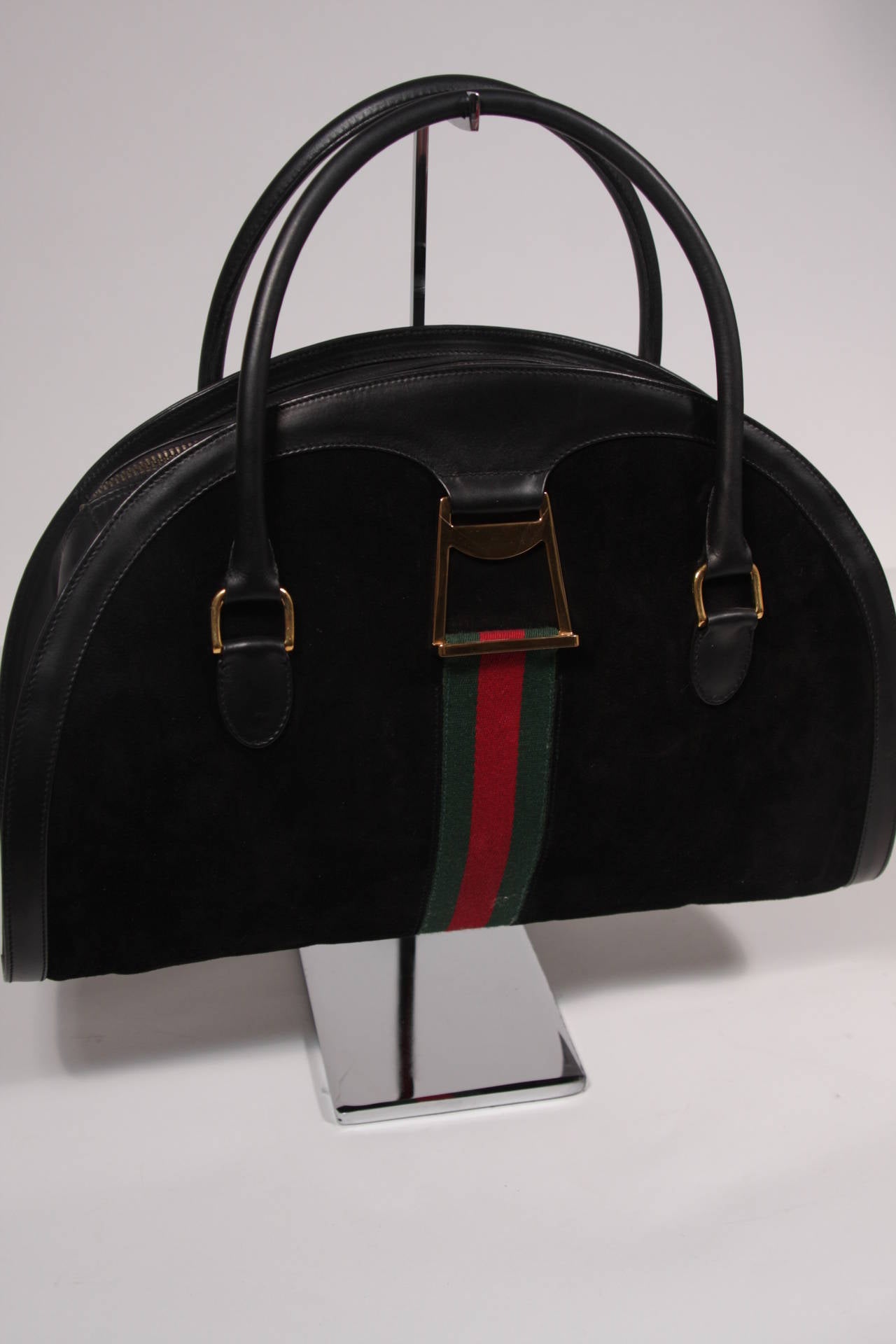 This is a wonderful Gucci vintage handbag. The purse features a classic Gucci green and red stripe with gold hardware. There is a top zipper closure which is tarnished. The handbag itself appears practically unused, except for the discoloration and