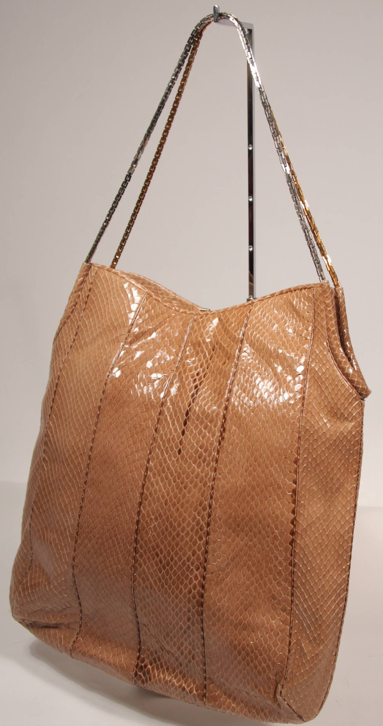 This is a gorgeous Judith Leiber purse. The handbag is composed of a striking nude snakeskin and features a two tone chain. There is a one interior zipper compartment and a snap closure. Comes with mirror and coin purse. This purse was hardly used,