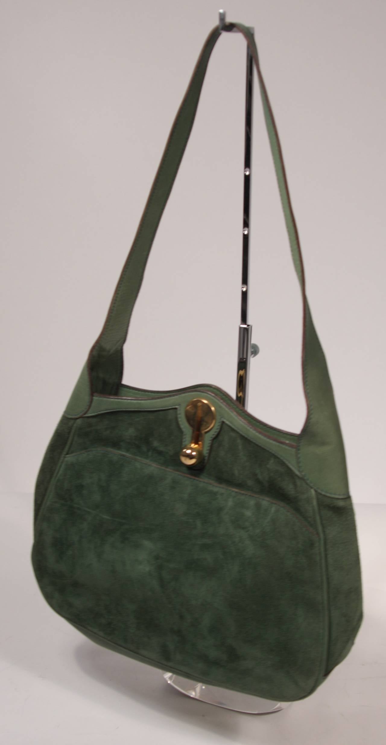 This is a Gucci vintage handbag. The hobo style purse is composed of a green leather and suede. There is a gold ball slide closure. The handbag is in excellent condition and practically unused, the only wear is due to age. 

Measures