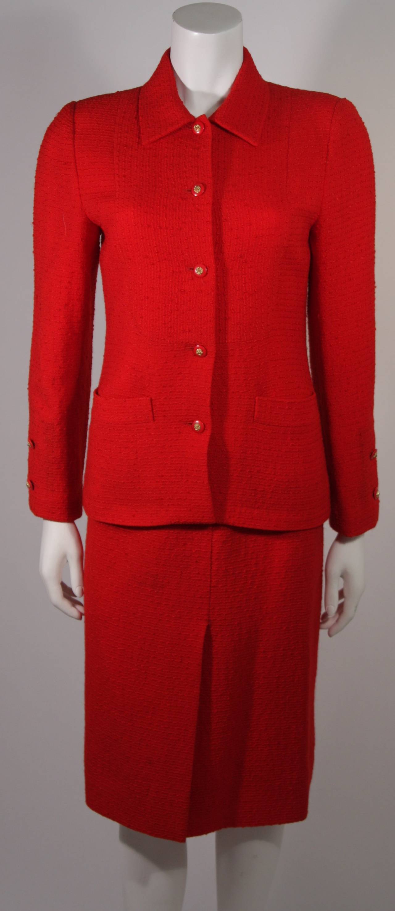 This is a beautiful Chanel skirt suit. The suit is composed of a wonderful red boucle fashioned out of a wool and silk blend. The Jacket features center front button closures, and the skirt has a side zipper with top button fastening. Wool/ Silk