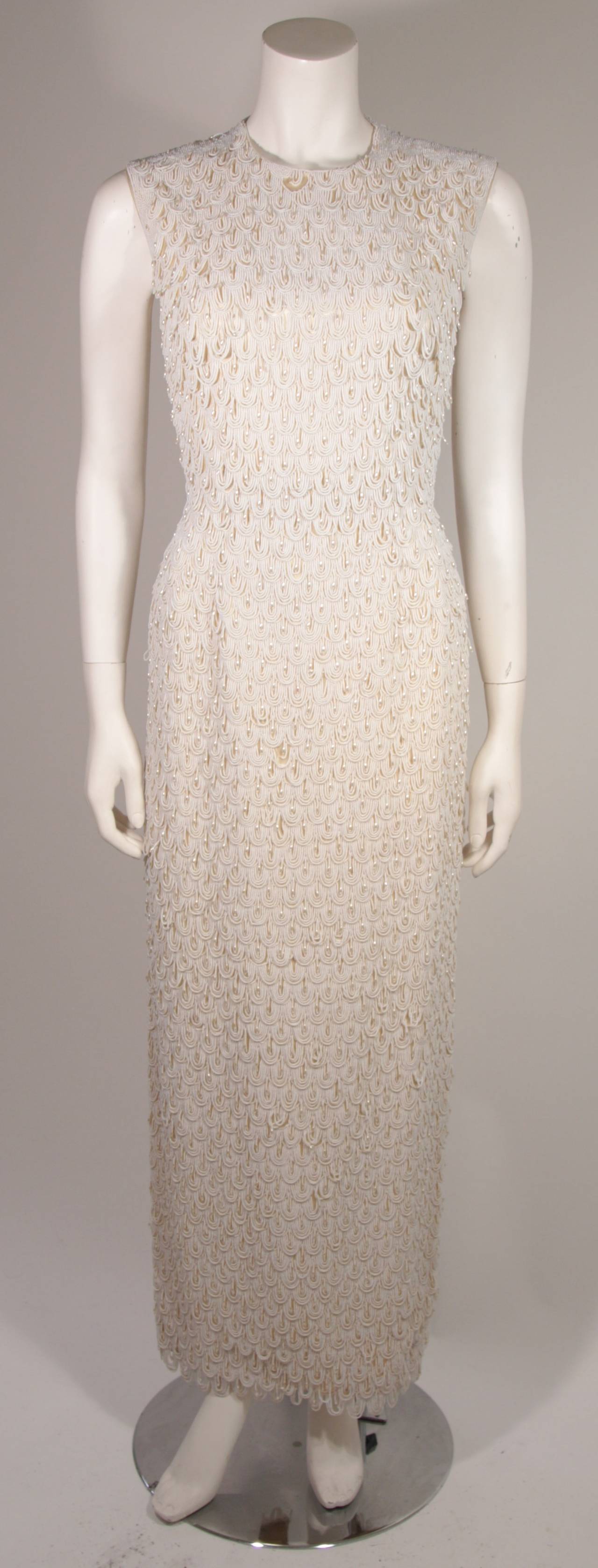 This is a stunning Ivory colored gown from the 1960's. The dress is fashioned with heavily beaded pearl like accents and adornments. There is a center back zipper for ease of access. Excellent vintage condition. Very substantial gown.

Measures
