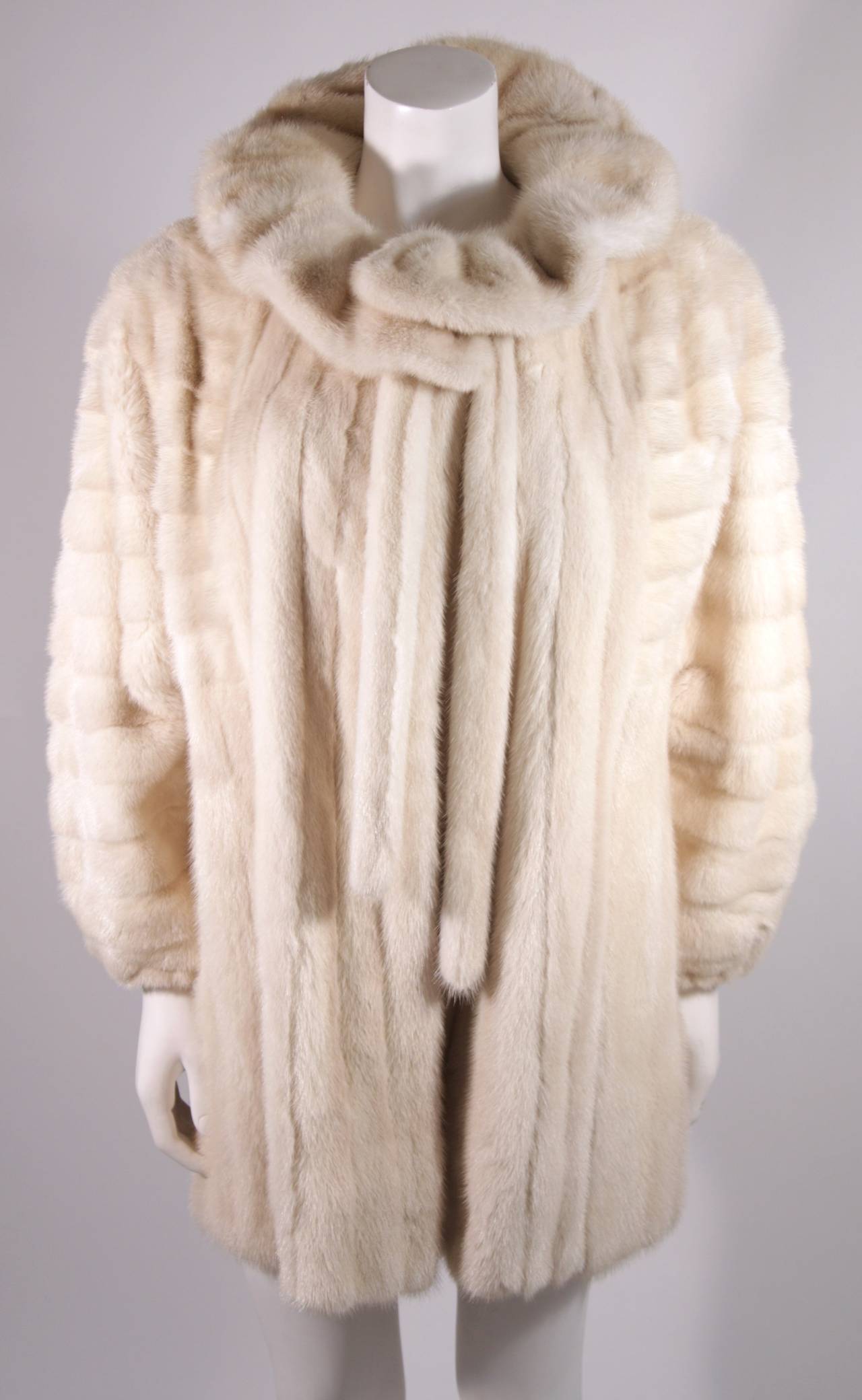 This is a delectable Galanos design. This fur coat is composed of an off white, Ivory hued mink. A great design which features a generous yet perfectly cut sleeve with a stretch cuff (to insulate) . A wonderful ruffle collar which can be worn up or