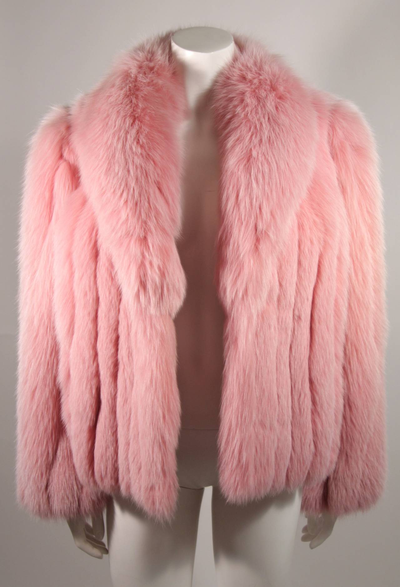 This is a fabulously lush fox fur coat. The coat is composed of a dense and supple pink dyed fox. The coat features two front side pockets. This coat is a delight. 

Measures (Approximately)
Length: 23.5