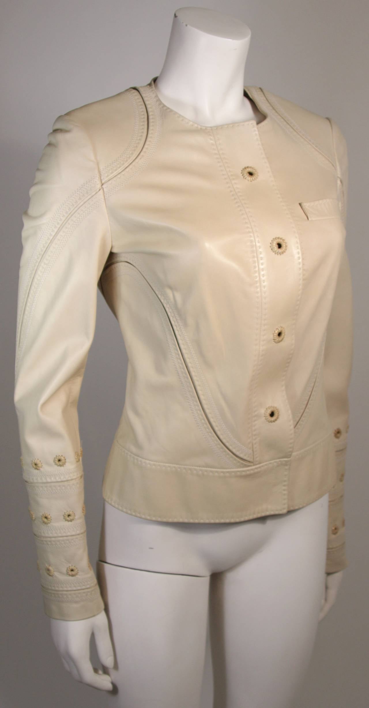 This is a Gucci jacket. The jacket is composed of an ultra light nude colored leather. There are center front closures; a zipper and large metal hook and eyes. Silk lining. Made in Italy. 

Measures (Approximately)
Length: 23