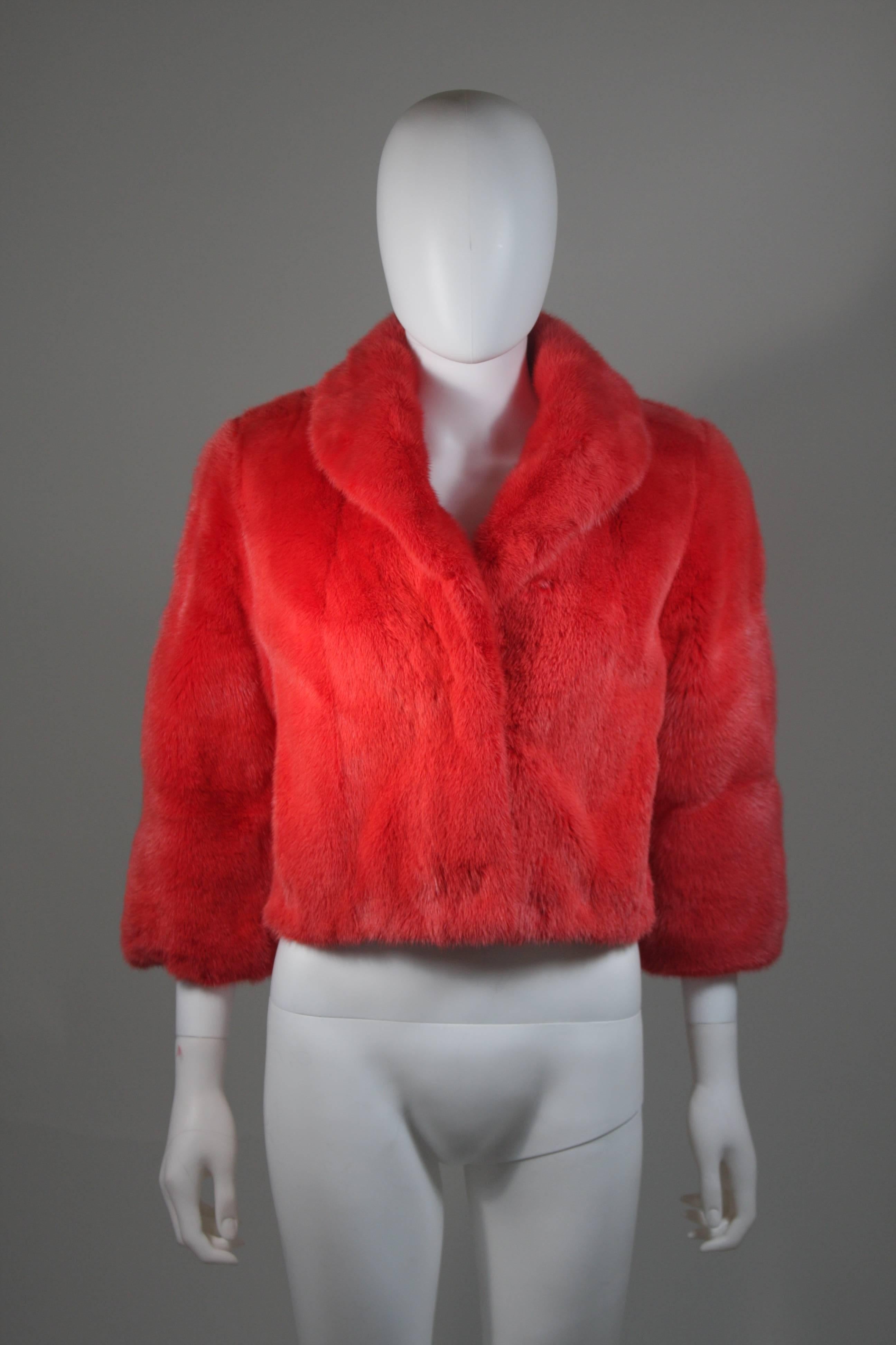 This mink jacket is composed of a female mink in an orange/pink hue (comparable to a watermelon or strawberry tone). There are center front closures and side pockets. In excellent condition. Made in France. 

  **Please cross-reference