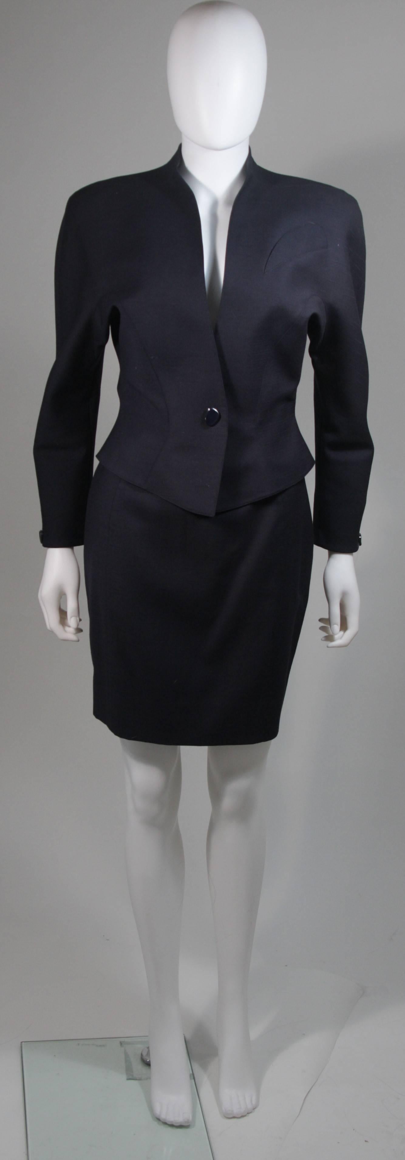  This skirt suit is composed of a  navy material. The jacket has a center front snap closure with button detail. The skirt has a classic pencil silhouette with zipper closure. In excellent vintage condition. Made in France. 

  **Please